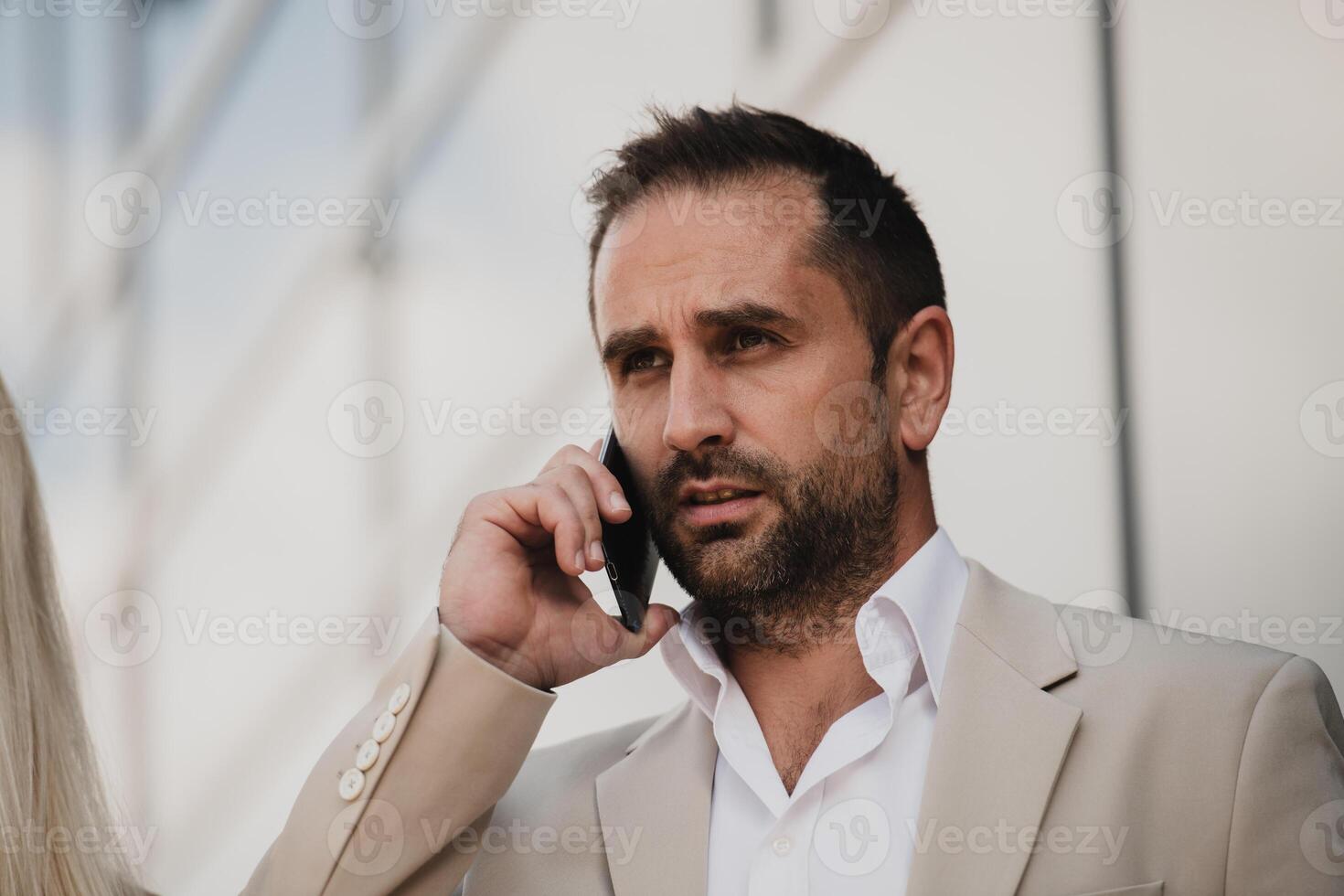 A businessman using his smartphone outdoors, showcasing the seamless integration of technology and mobility in modern professional life. photo