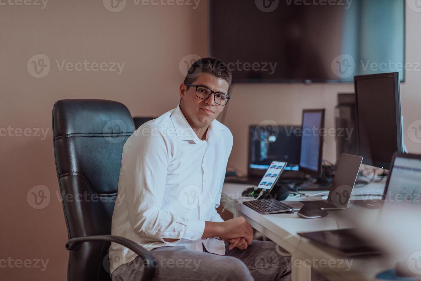 A programmer diligently testing smartphone applications while sitting in their office. photo