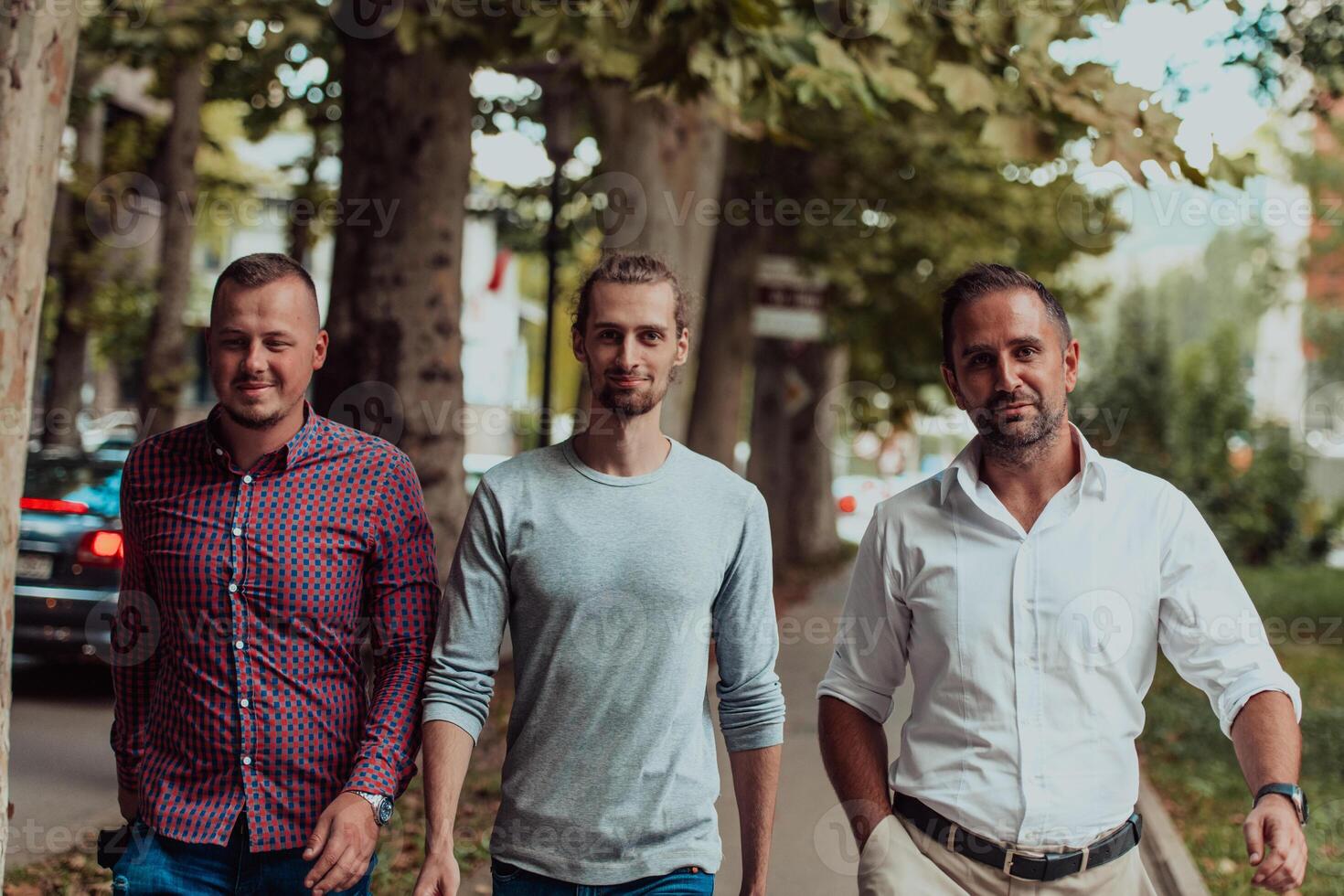 After a productive day at work, a group of diverse colleagues enjoy a leisurely stroll through a modern and natural urban setting photo