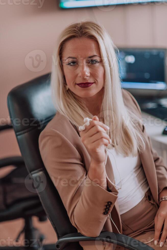 A businesswoman sitting in a programmer's office surrounded by computers, showing her expertise and dedication to technology. photo