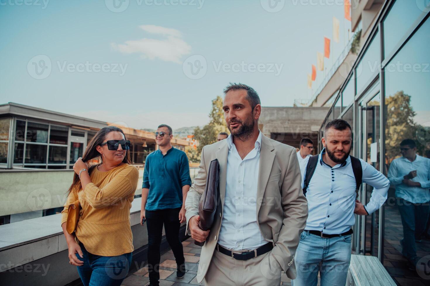 A diverse group of businessmen and colleagues walking together by their workplace, showcasing collaboration and teamwork in the company. photo