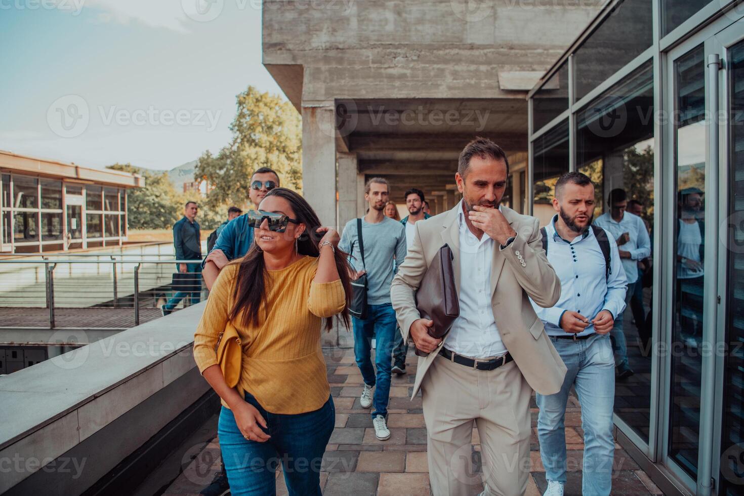 A diverse group of businessmen and colleagues walking together by their workplace, showcasing collaboration and teamwork in the company. photo