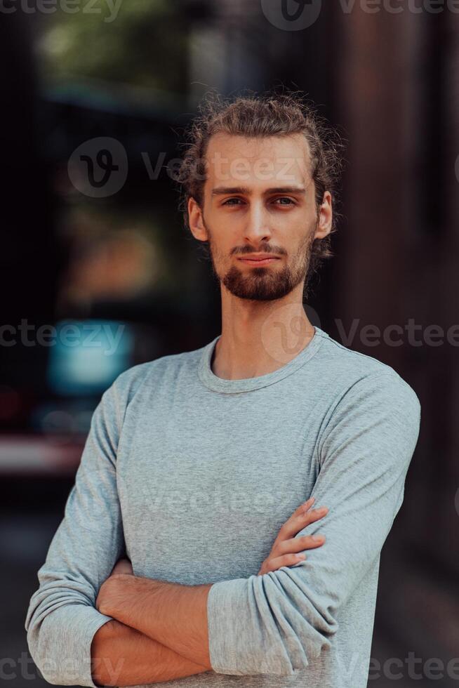 Portrait of a young successful businessman with crossed arms in front of the company photo