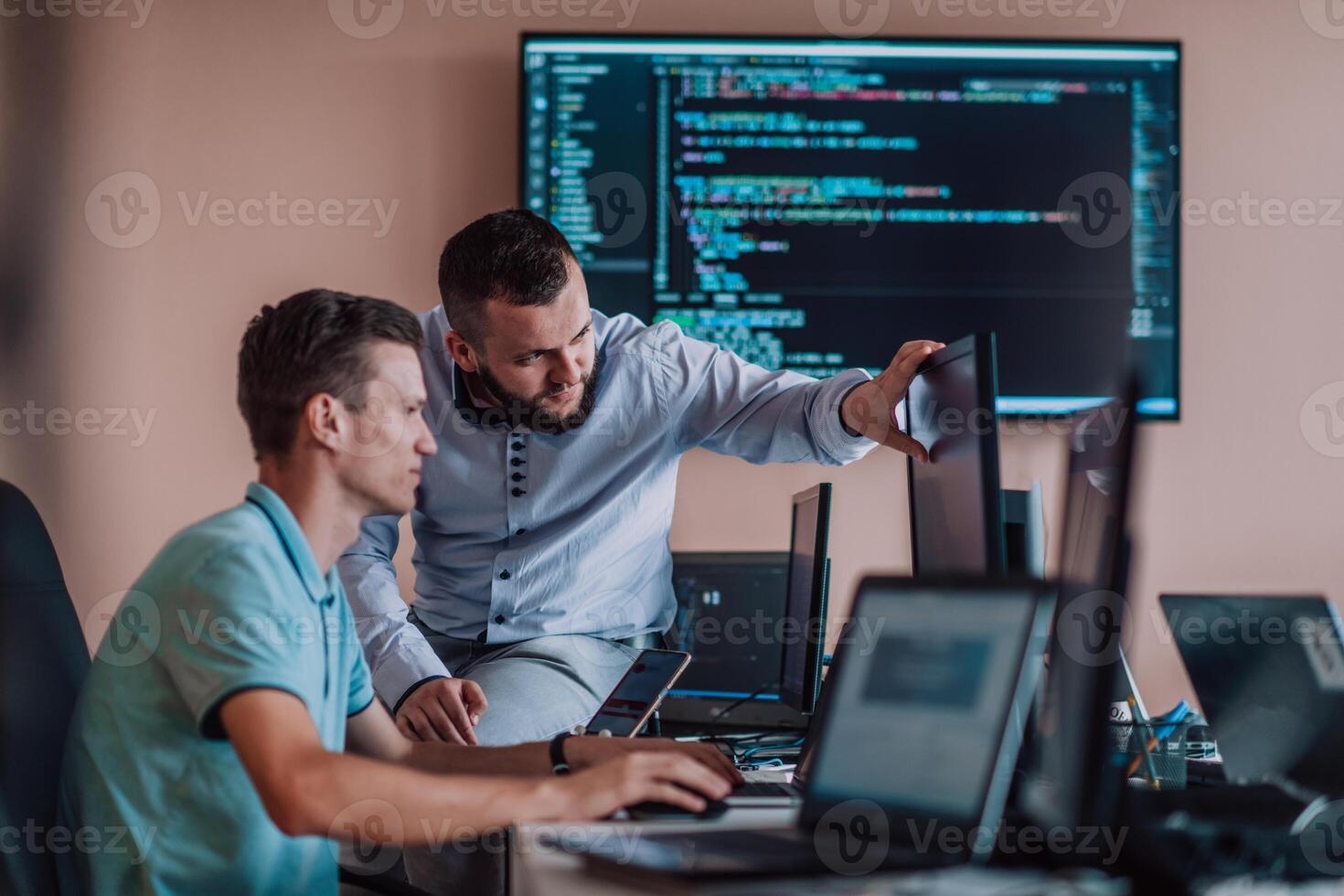 Programmers engrossed in deep collaboration, diligently working together to solve complex problems and develop innovative mobile applications with seamless functionality. photo