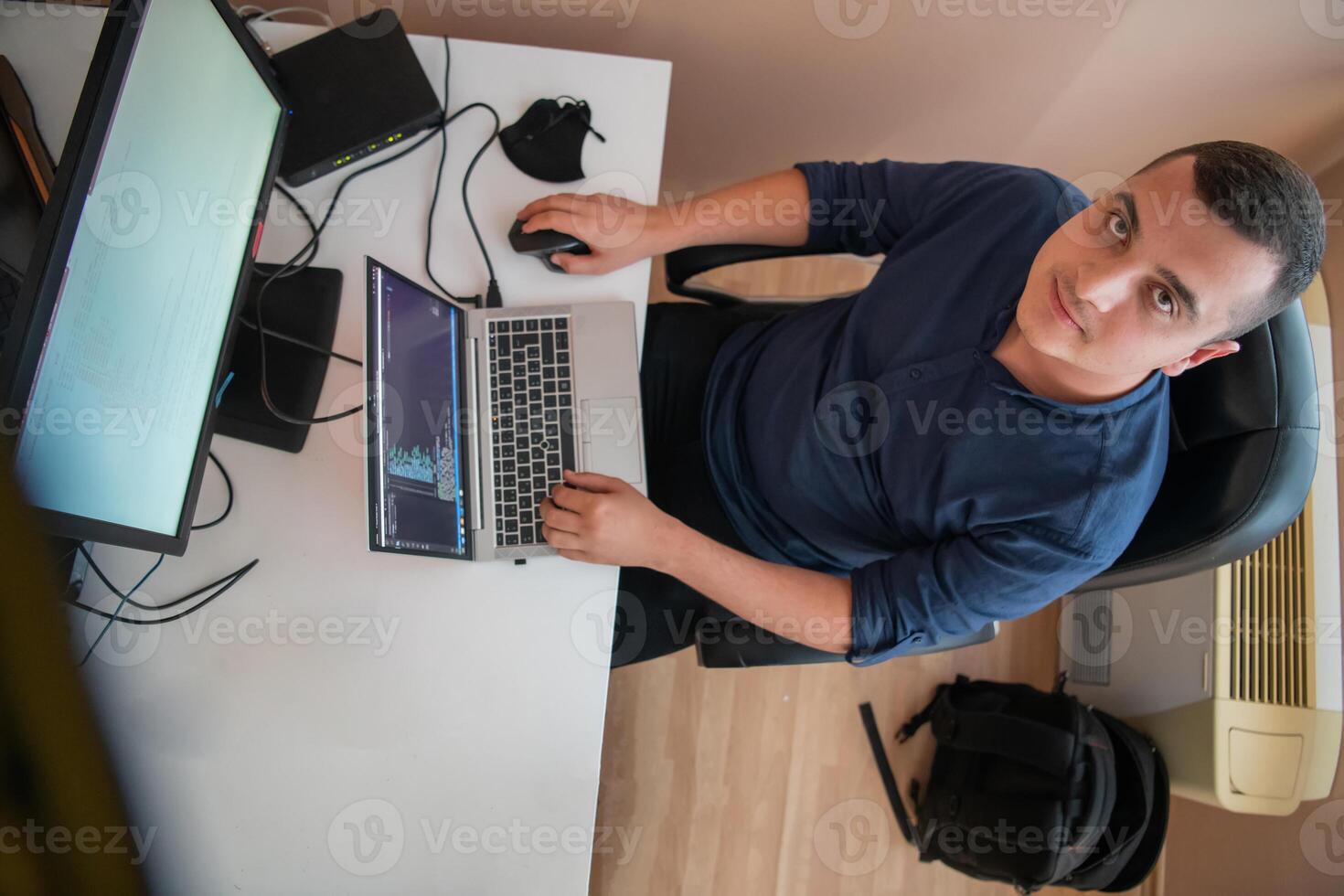 Top view of programmer diligently testing smartphone applications while sitting in their office. photo