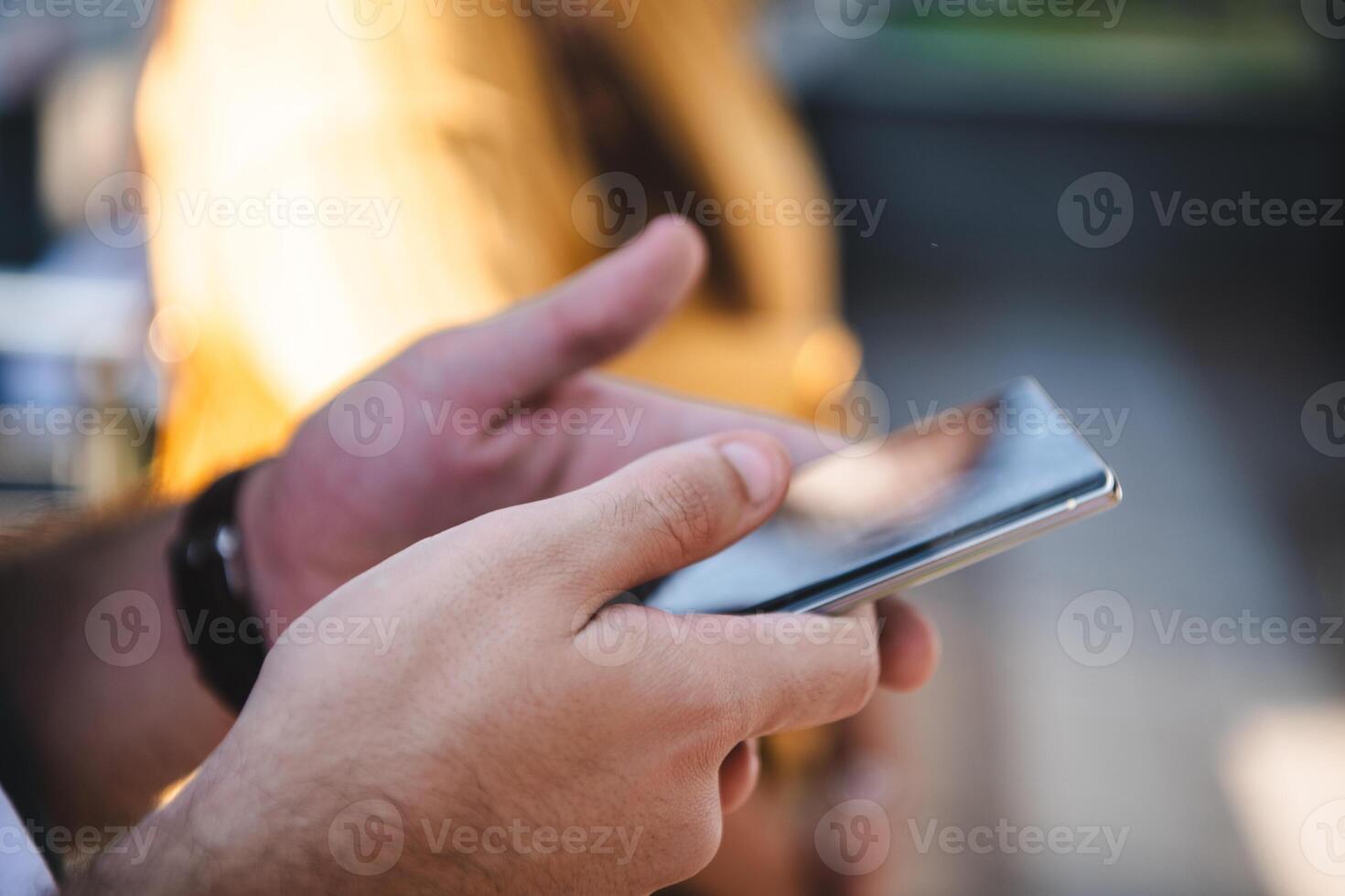 Closeup photo of businessman hand utilizes his smartphone outdoors, showcasing the seamless integration of technology and mobility in modern professional life.