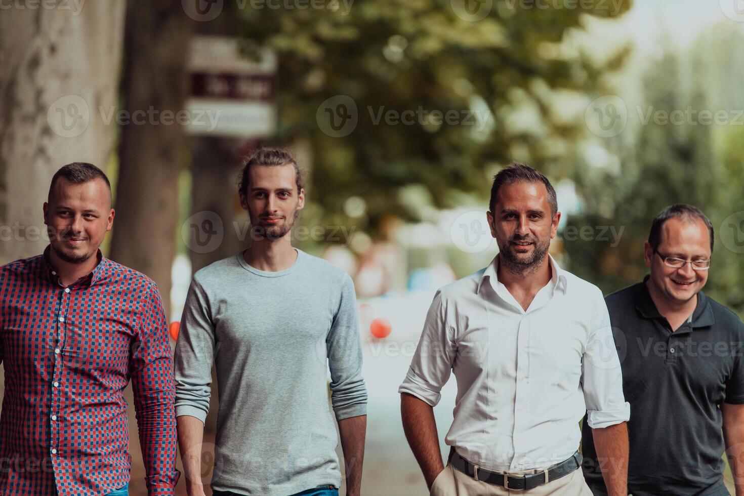 After a productive day at work, a group of diverse colleagues enjoy a leisurely stroll through a modern and natural urban setting photo