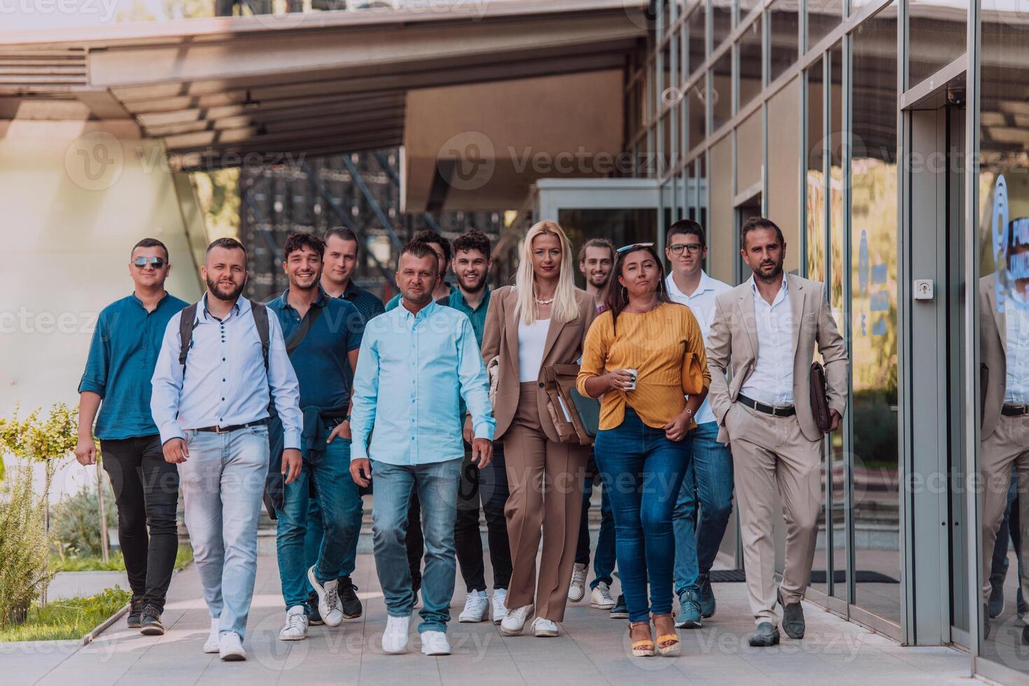 A diverse group of businessmen and colleagues walking together by their workplace, showcasing collaboration and teamwork in the company. photo