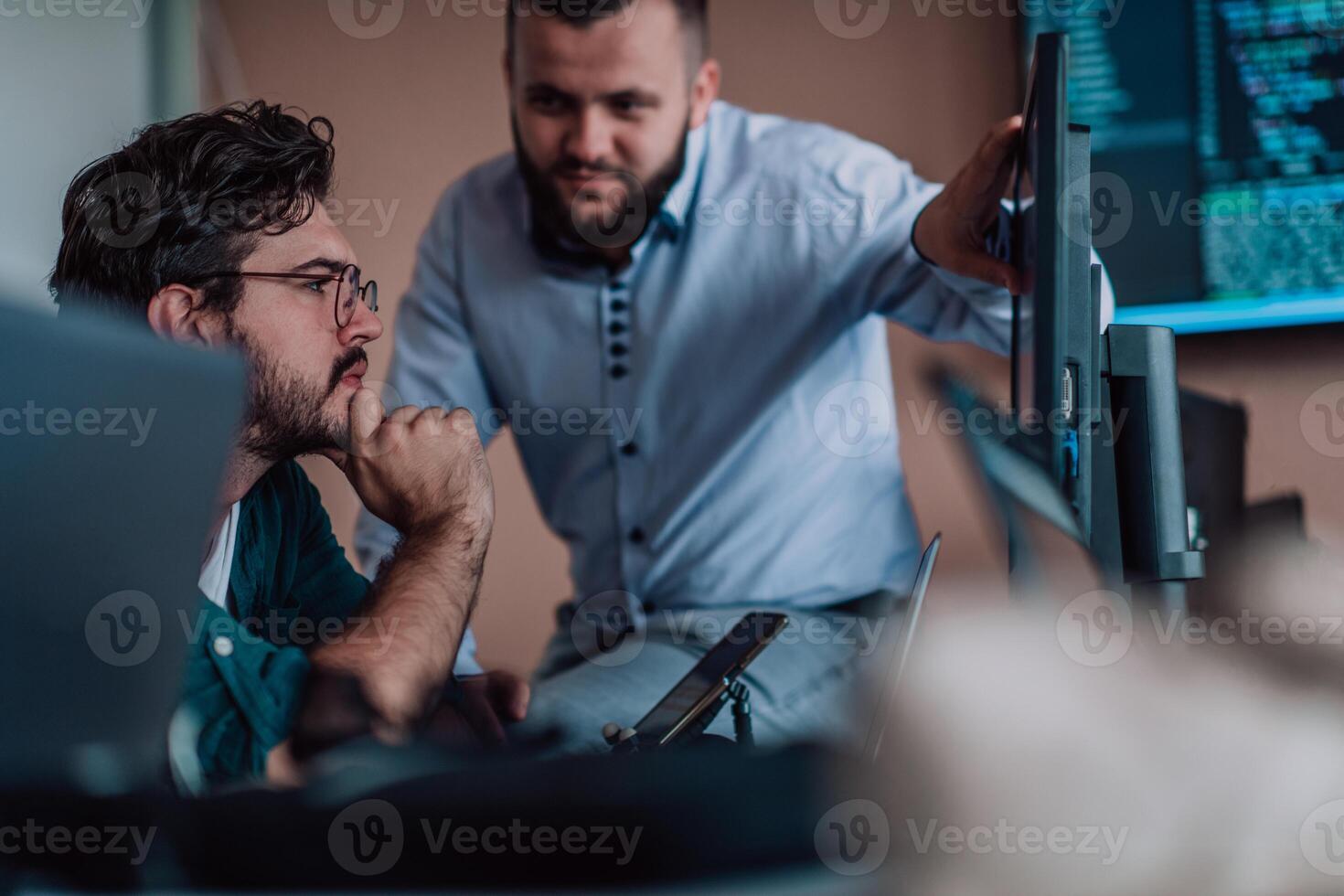 Programmers engrossed in deep collaboration, diligently working together to solve complex problems and develop innovative mobile applications with seamless functionality. photo