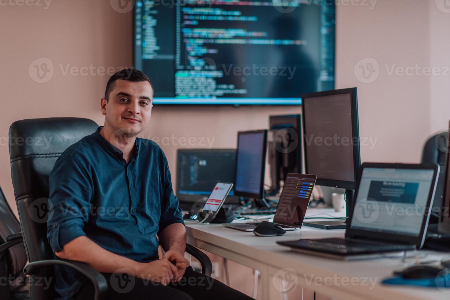 A programmer diligently testing smartphone applications while sitting in their office. photo