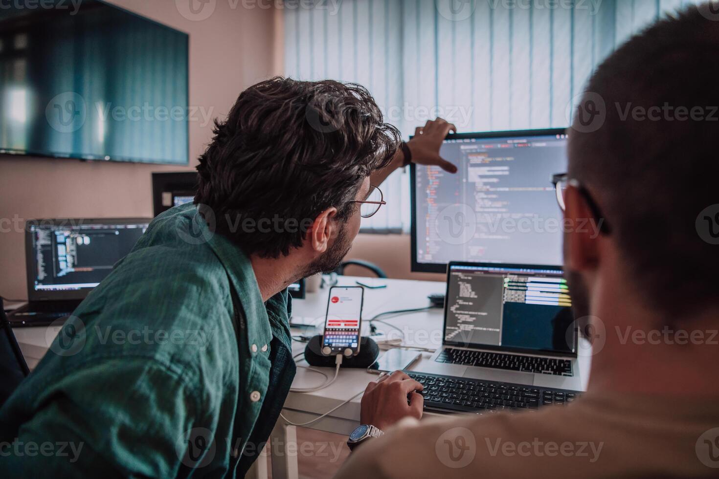 Programmers engrossed in deep collaboration, diligently working together to solve complex problems and develop innovative mobile applications with seamless functionality. photo