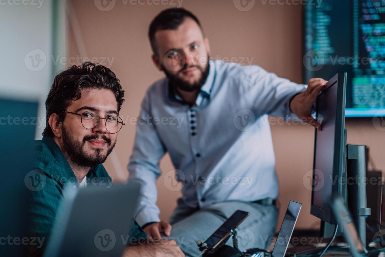 Programmers engrossed in deep collaboration, diligently working together to solve complex problems and develop innovative mobile applications with seamless functionality. photo
