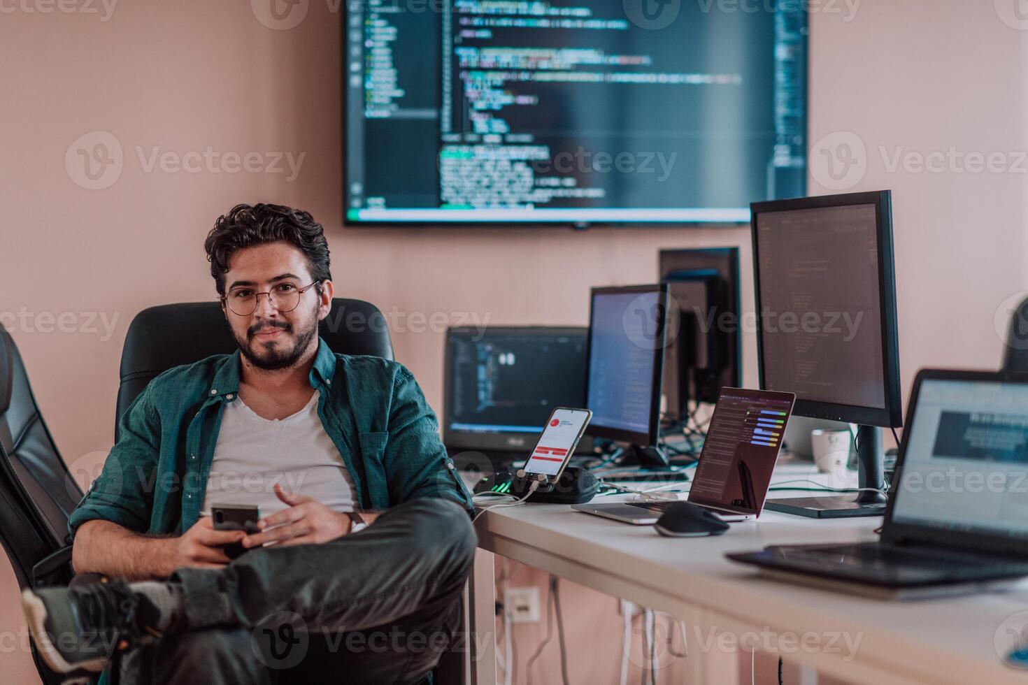 A programmer diligently testing smartphone applications while sitting in their office. photo