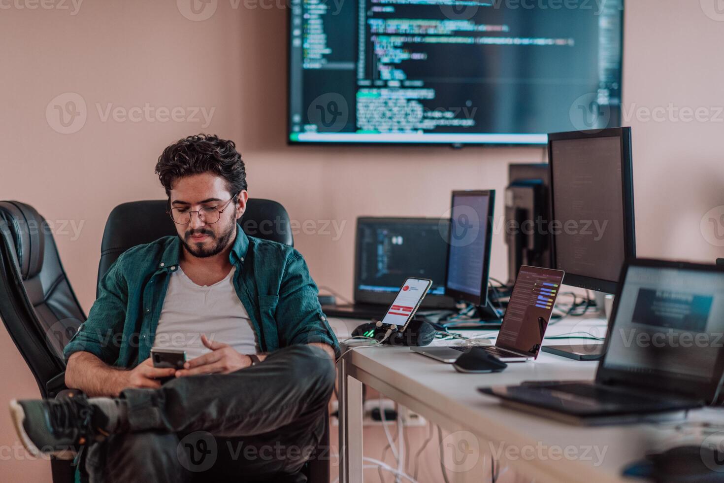 A programmer diligently testing smartphone applications while sitting in their office. photo