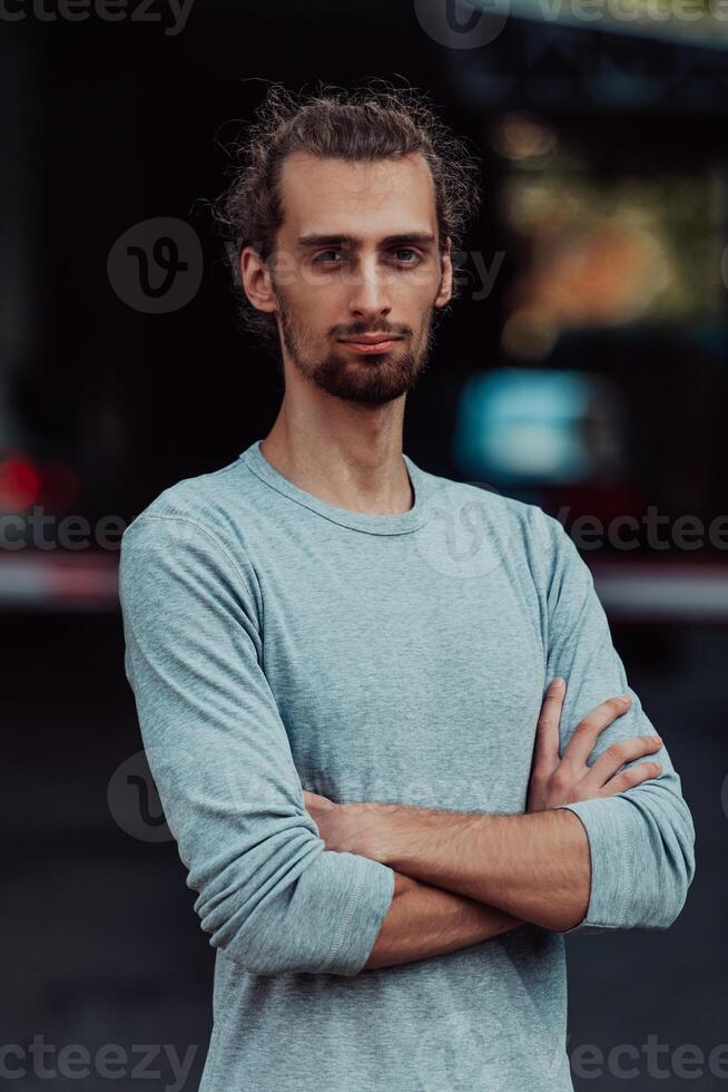 Portrait of a young successful businessman with crossed arms in front of the company photo