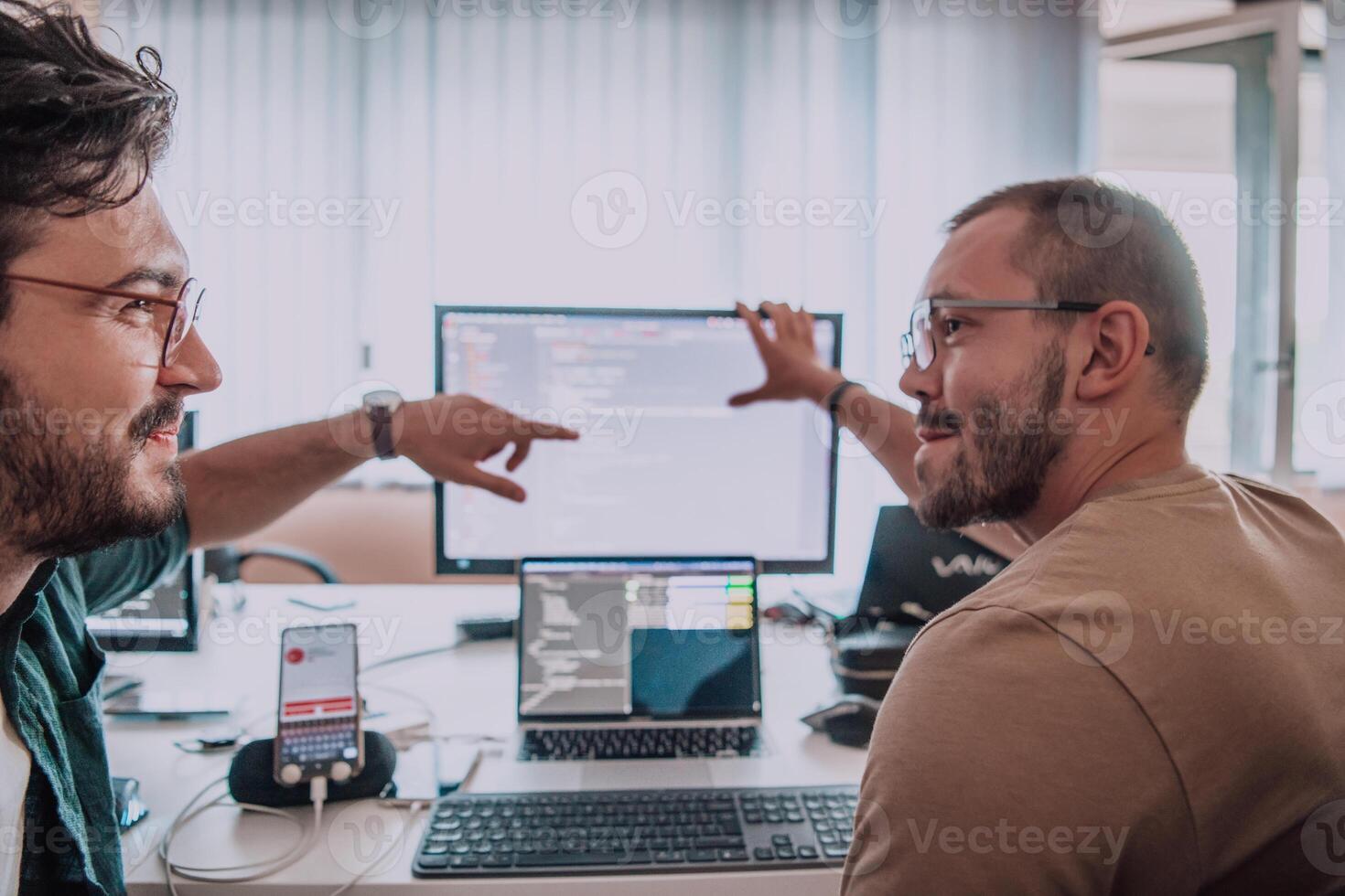 Programmers engrossed in deep collaboration, diligently working together to solve complex problems and develop innovative mobile applications with seamless functionality. photo