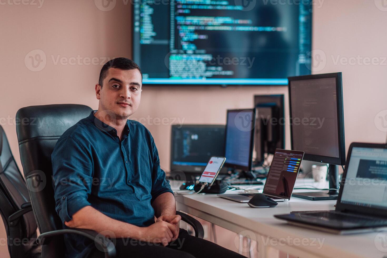 A programmer diligently testing smartphone applications while sitting in their office. photo
