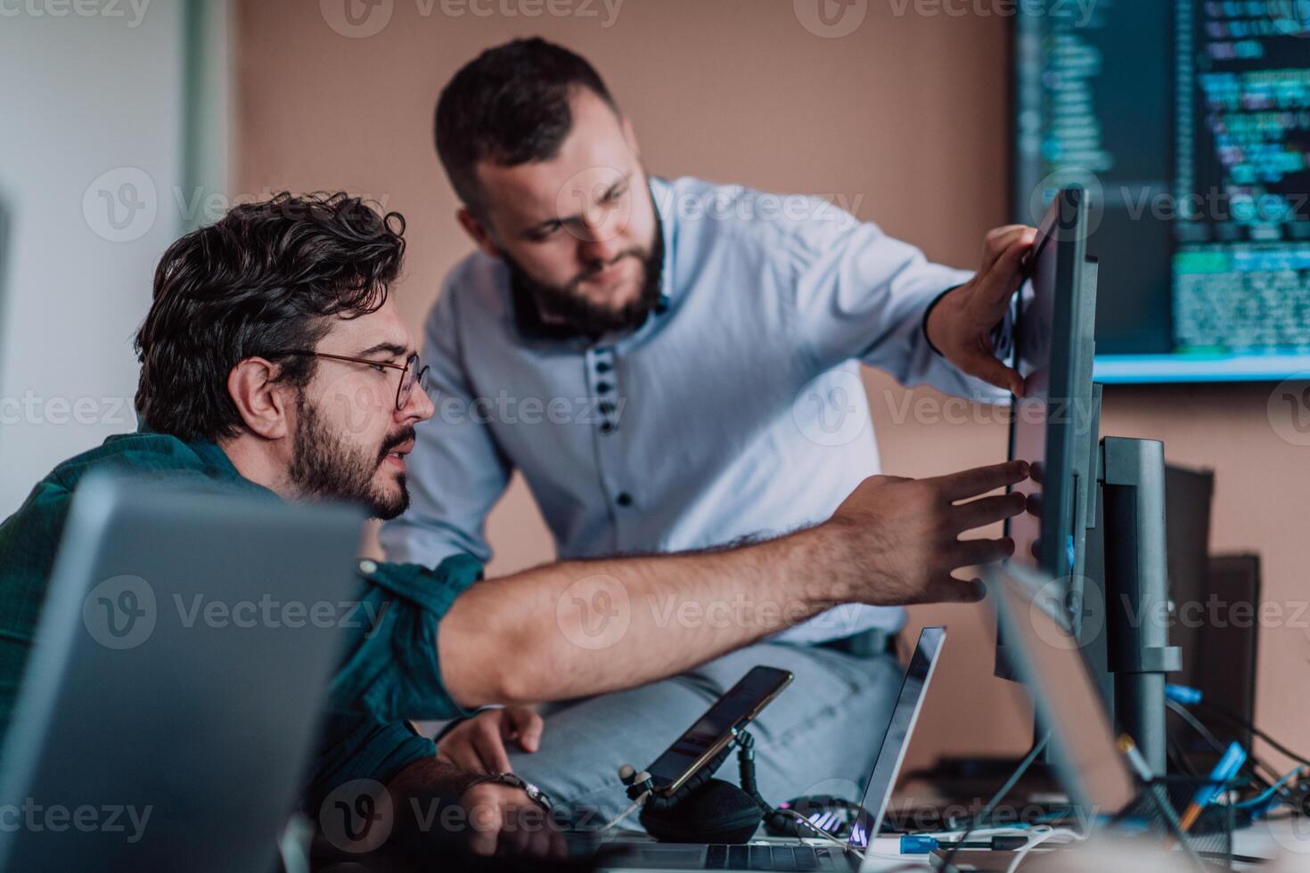 Programmers engrossed in deep collaboration, diligently working together to solve complex problems and develop innovative mobile applications with seamless functionality. photo