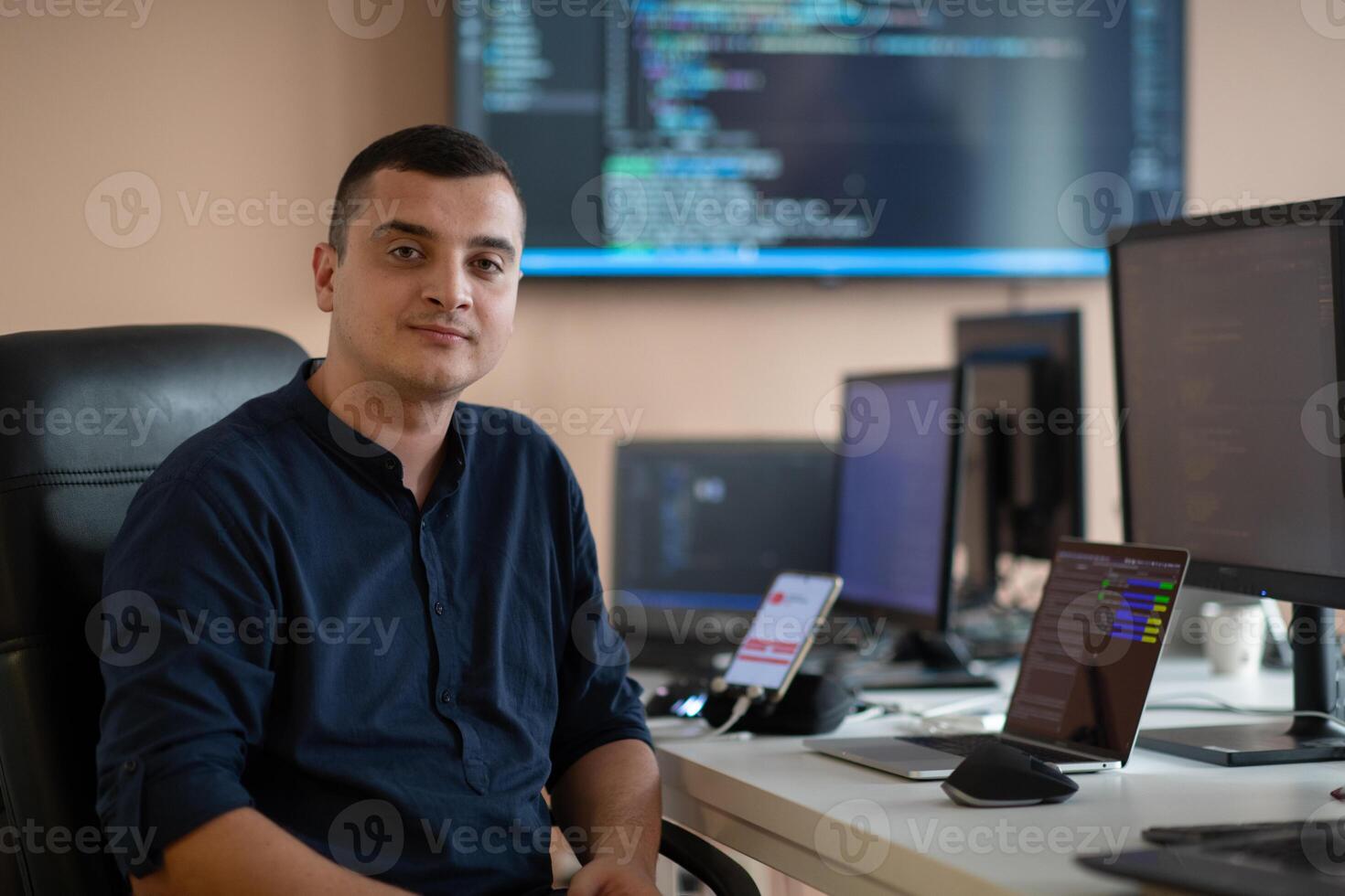 A programmer diligently testing smartphone applications while sitting in their office. photo