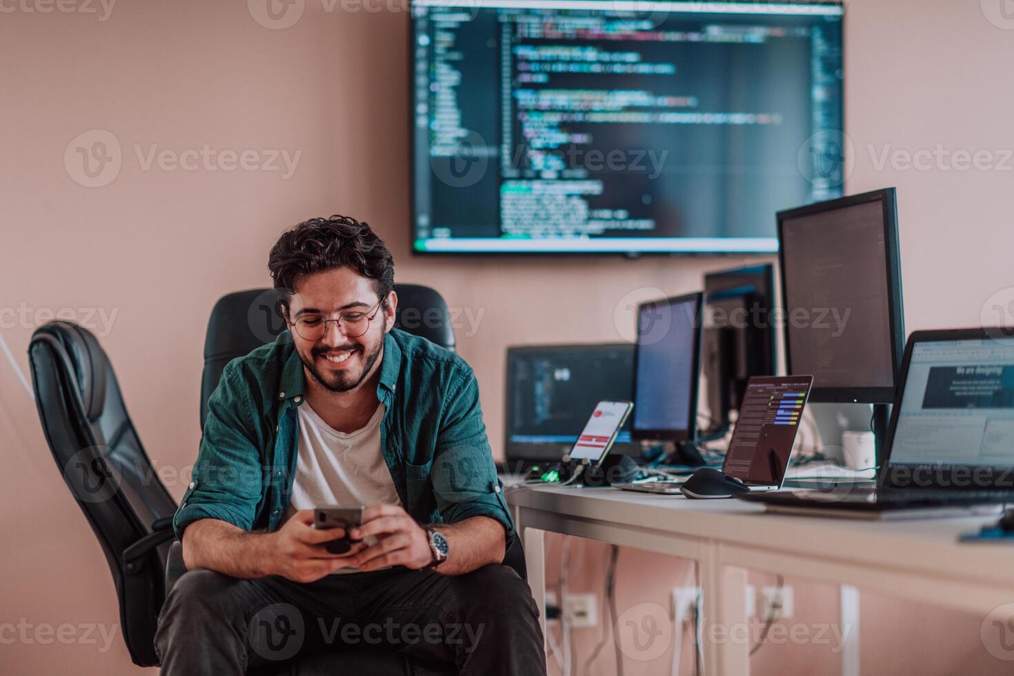 A programmer diligently testing smartphone applications while sitting in their office. photo