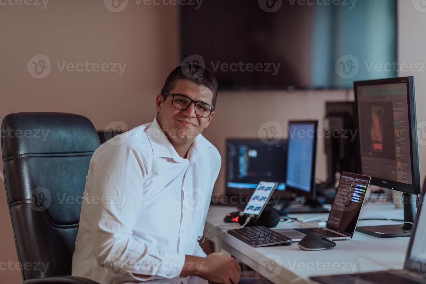 A programmer diligently testing smartphone applications while sitting in their office. photo