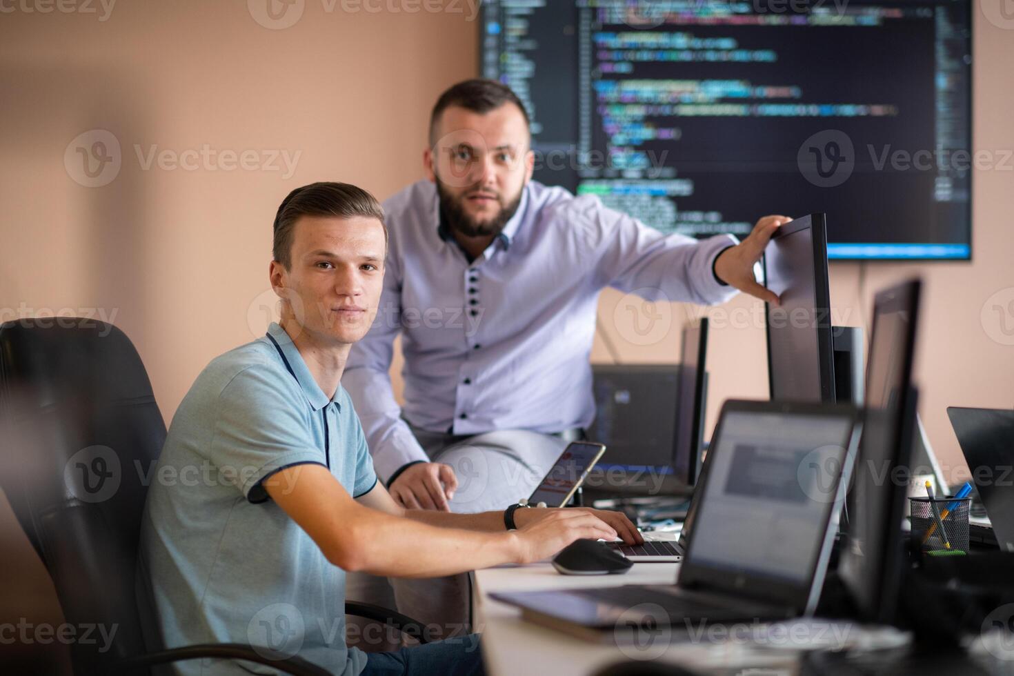 Programmers engrossed in deep collaboration, diligently working together to solve complex problems photo