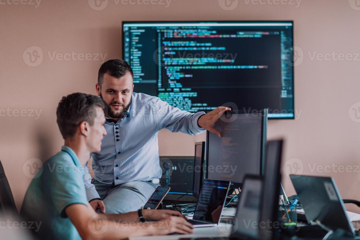 Programmers engrossed in deep collaboration, diligently working together to solve complex problems and develop innovative mobile applications with seamless functionality. photo