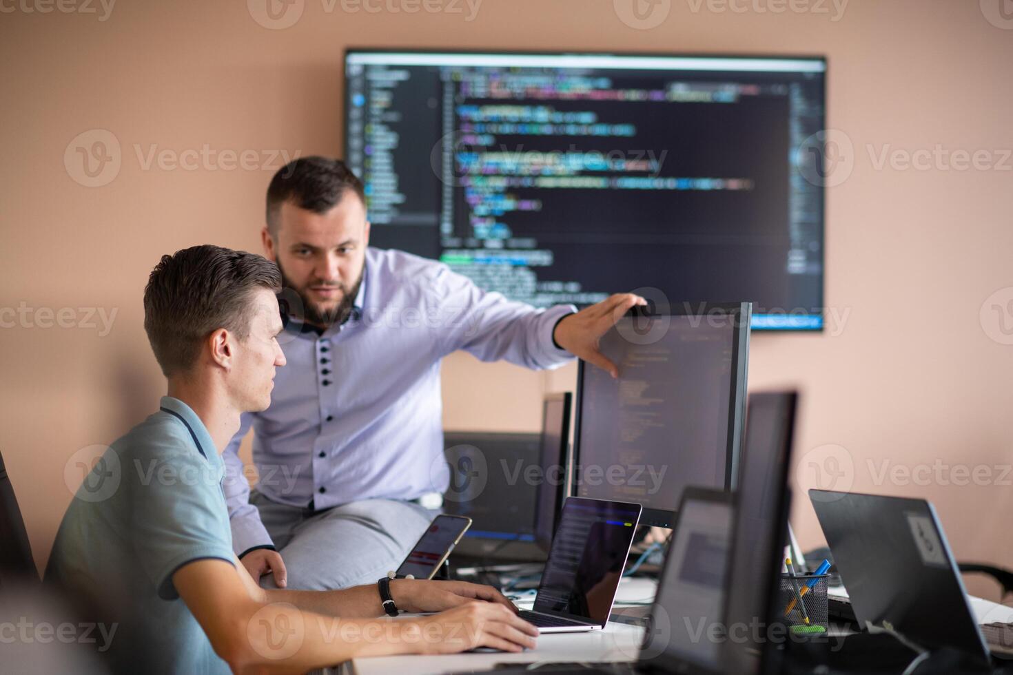 Programmers engrossed in deep collaboration, diligently working together to solve complex problems photo