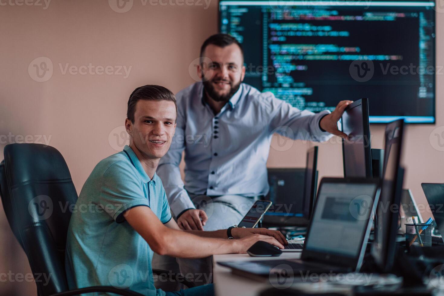 Programmers engrossed in deep collaboration, diligently working together to solve complex problems and develop innovative mobile applications with seamless functionality. photo