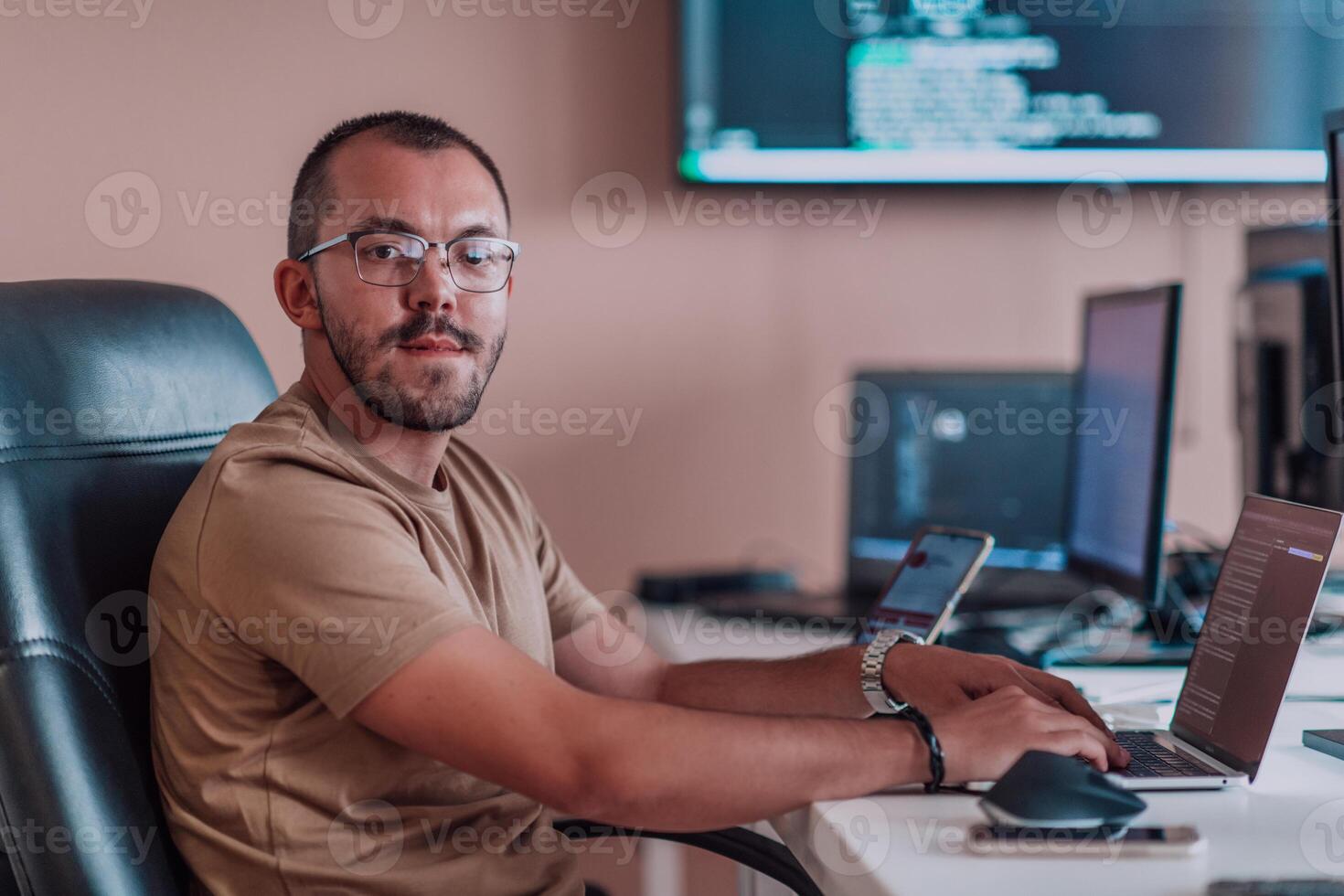 A programmer diligently testing smartphone applications while sitting in their office. photo