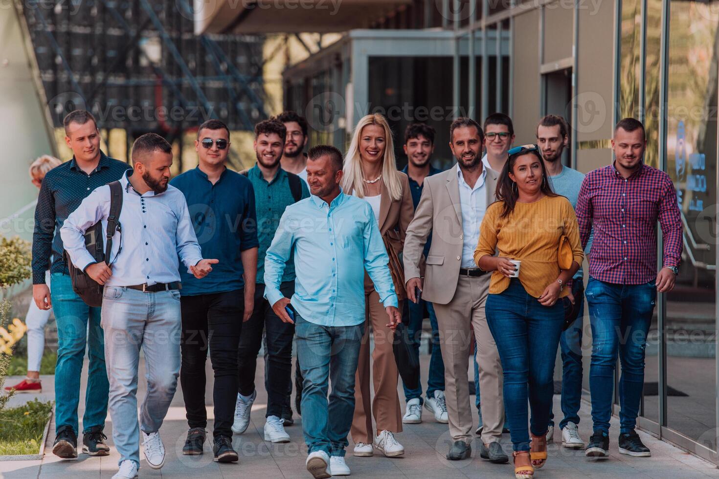 A diverse group of businessmen and colleagues walking together by their workplace, showcasing collaboration and teamwork in the company. photo