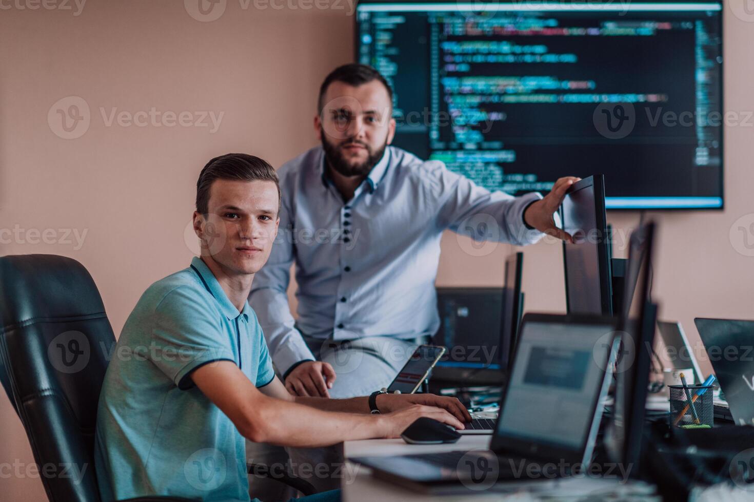 Programmers engrossed in deep collaboration, diligently working together to solve complex problems and develop innovative mobile applications with seamless functionality. photo