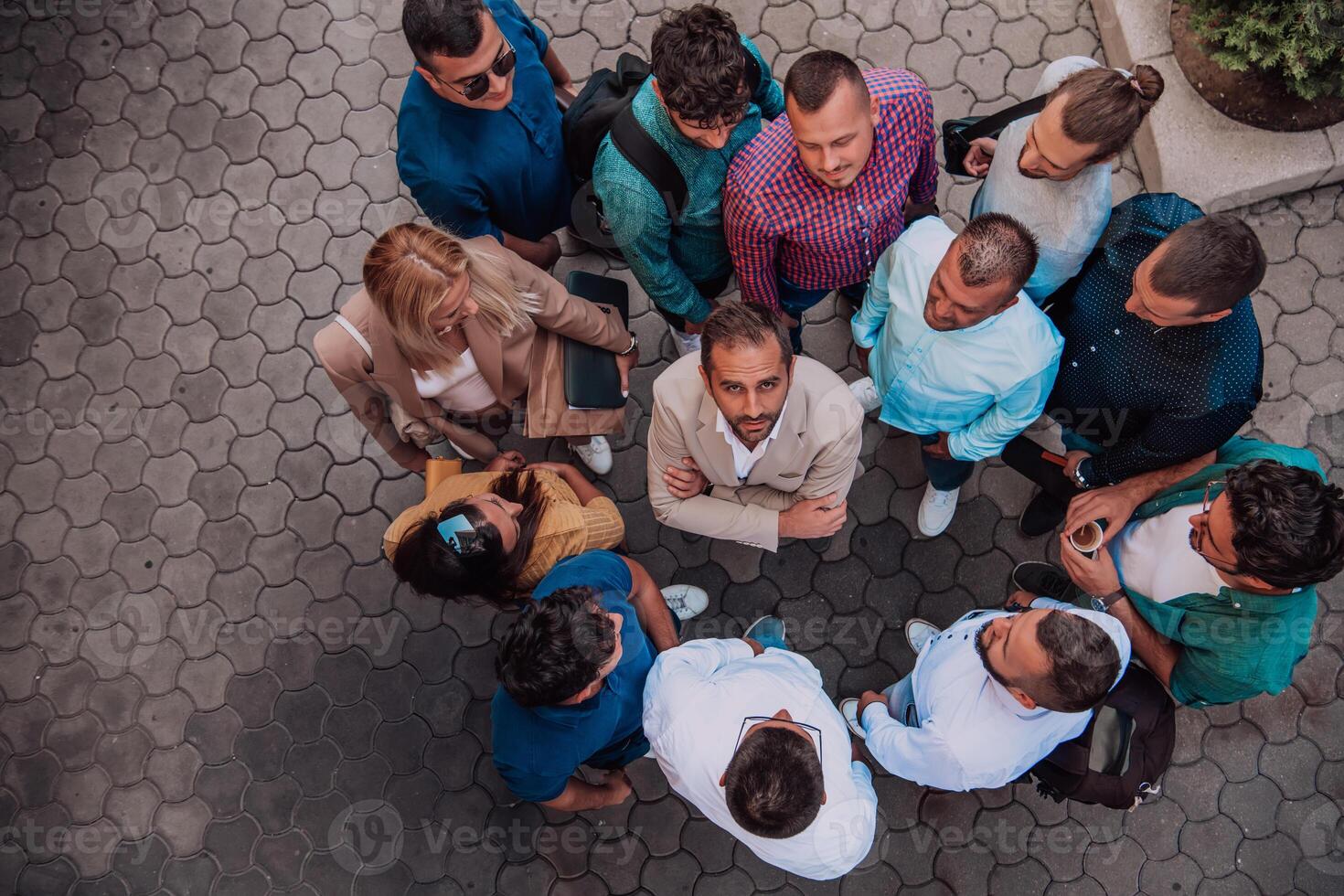 A top view photo of group of businessmen and colleagues standing together, looking towards the camera, symbolizing unity and teamwork.