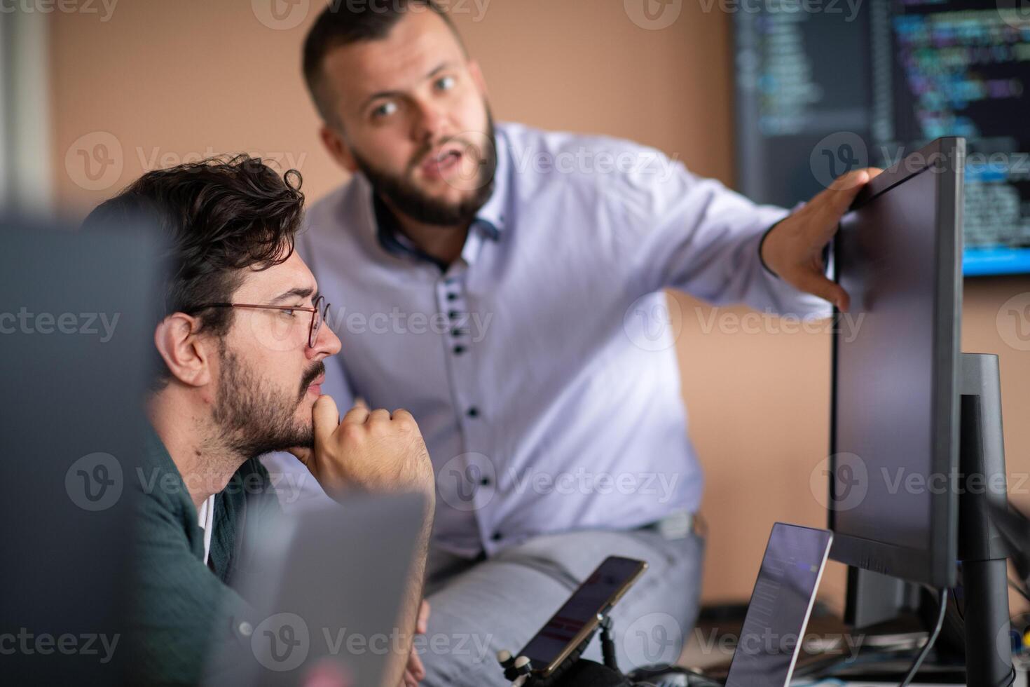 Programmers engrossed in deep collaboration, diligently working together to solve complex problems photo