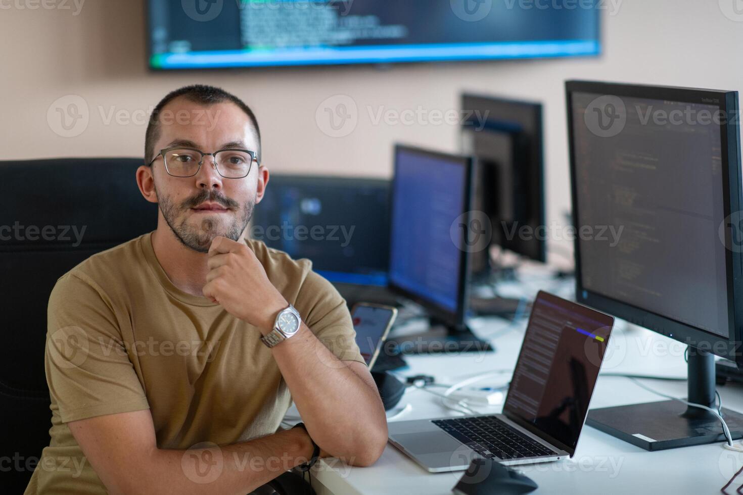 A programmer diligently testing smartphone applications while sitting in their office. photo