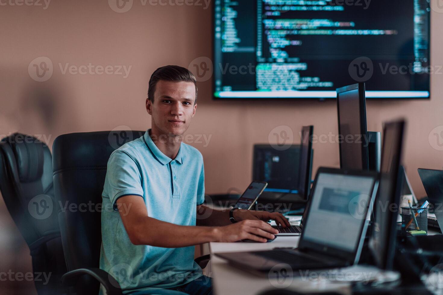 A programmer diligently testing smartphone applications while sitting in their office. photo