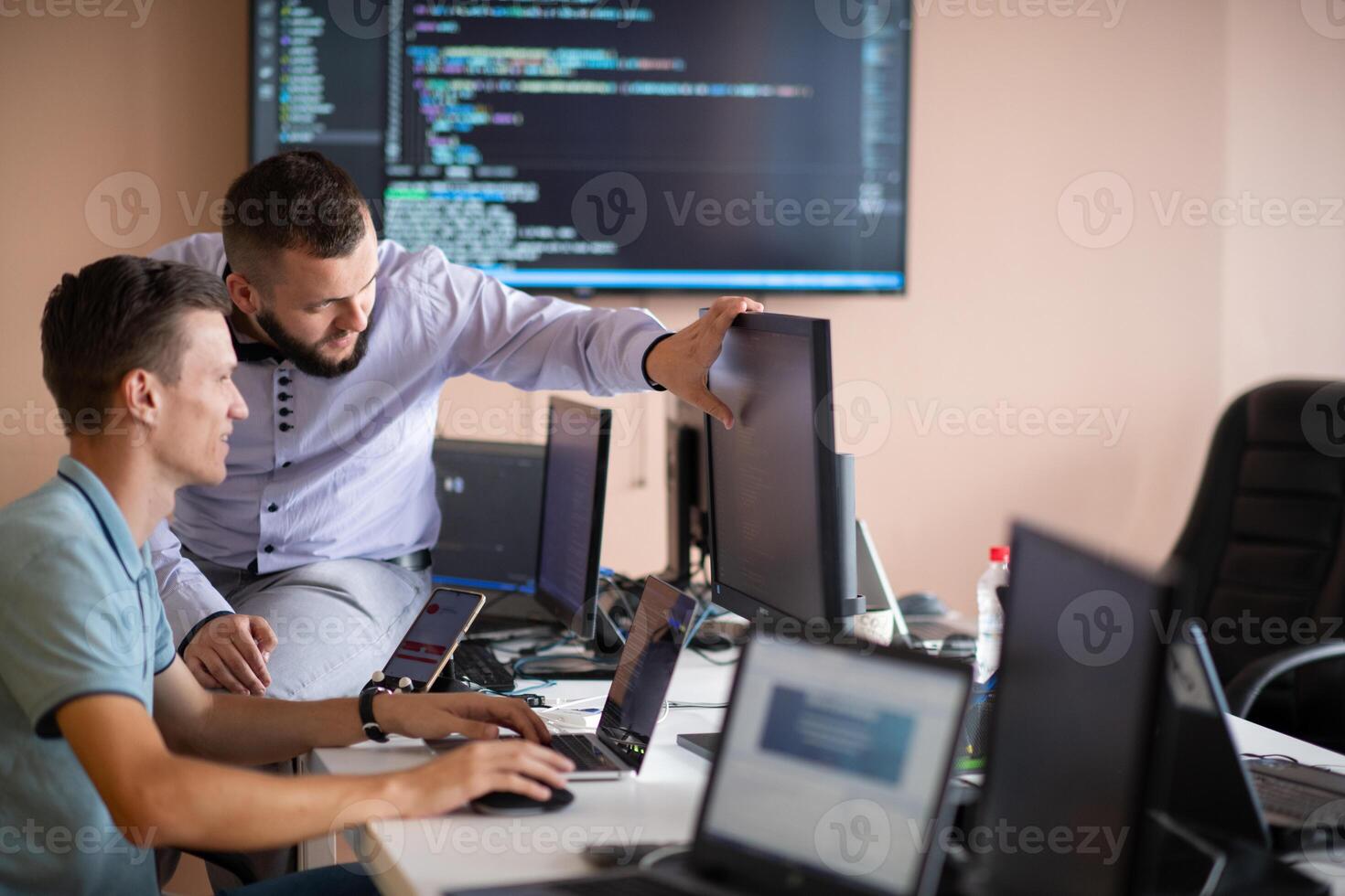 Programmers engrossed in deep collaboration, diligently working together to solve complex problems photo