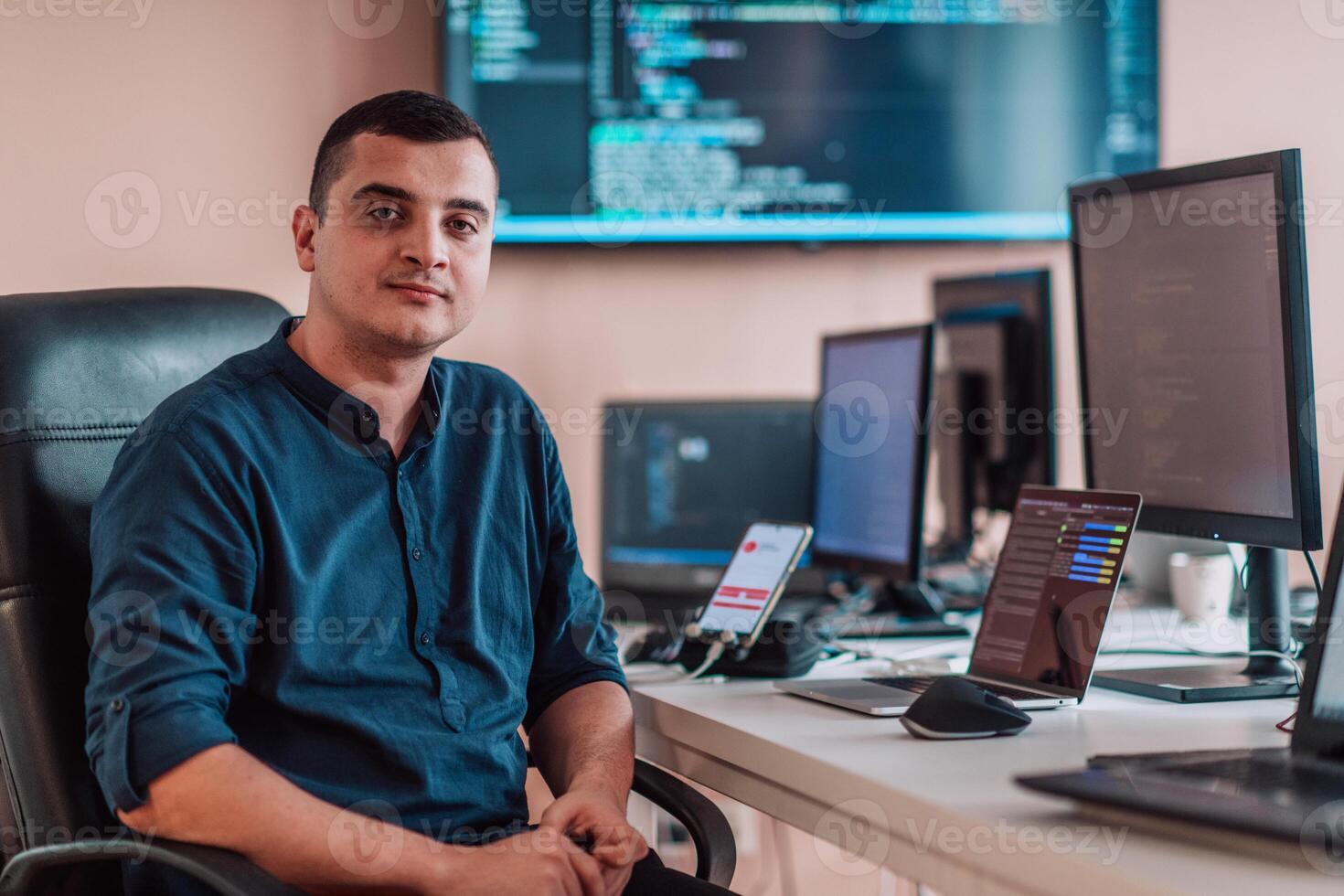 A programmer diligently testing smartphone applications while sitting in their office. photo