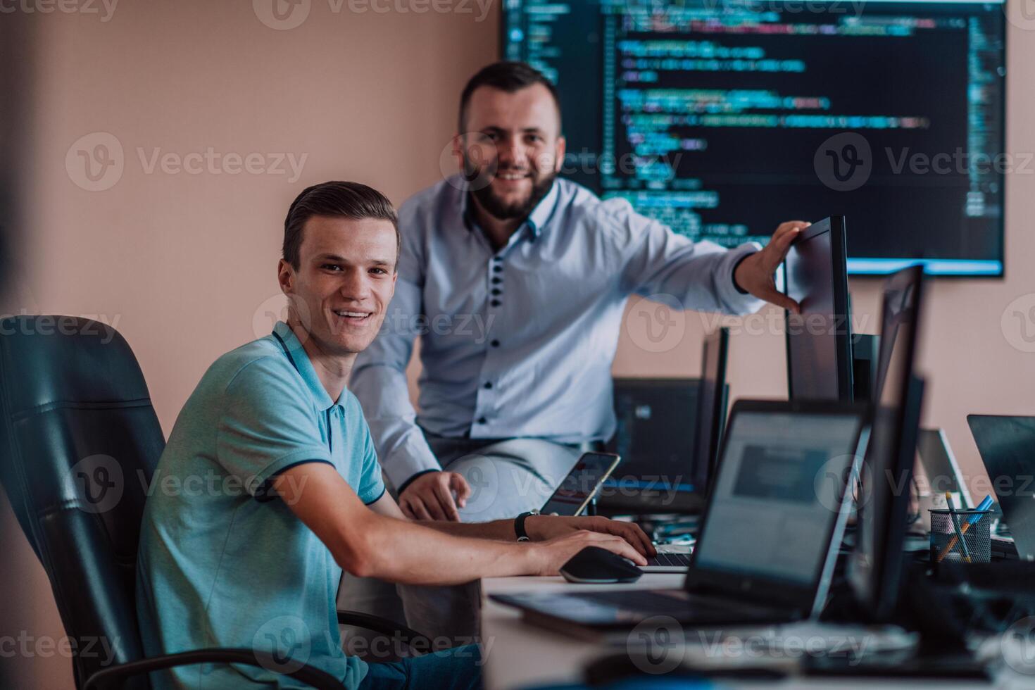 Programmers engrossed in deep collaboration, diligently working together to solve complex problems and develop innovative mobile applications with seamless functionality. photo