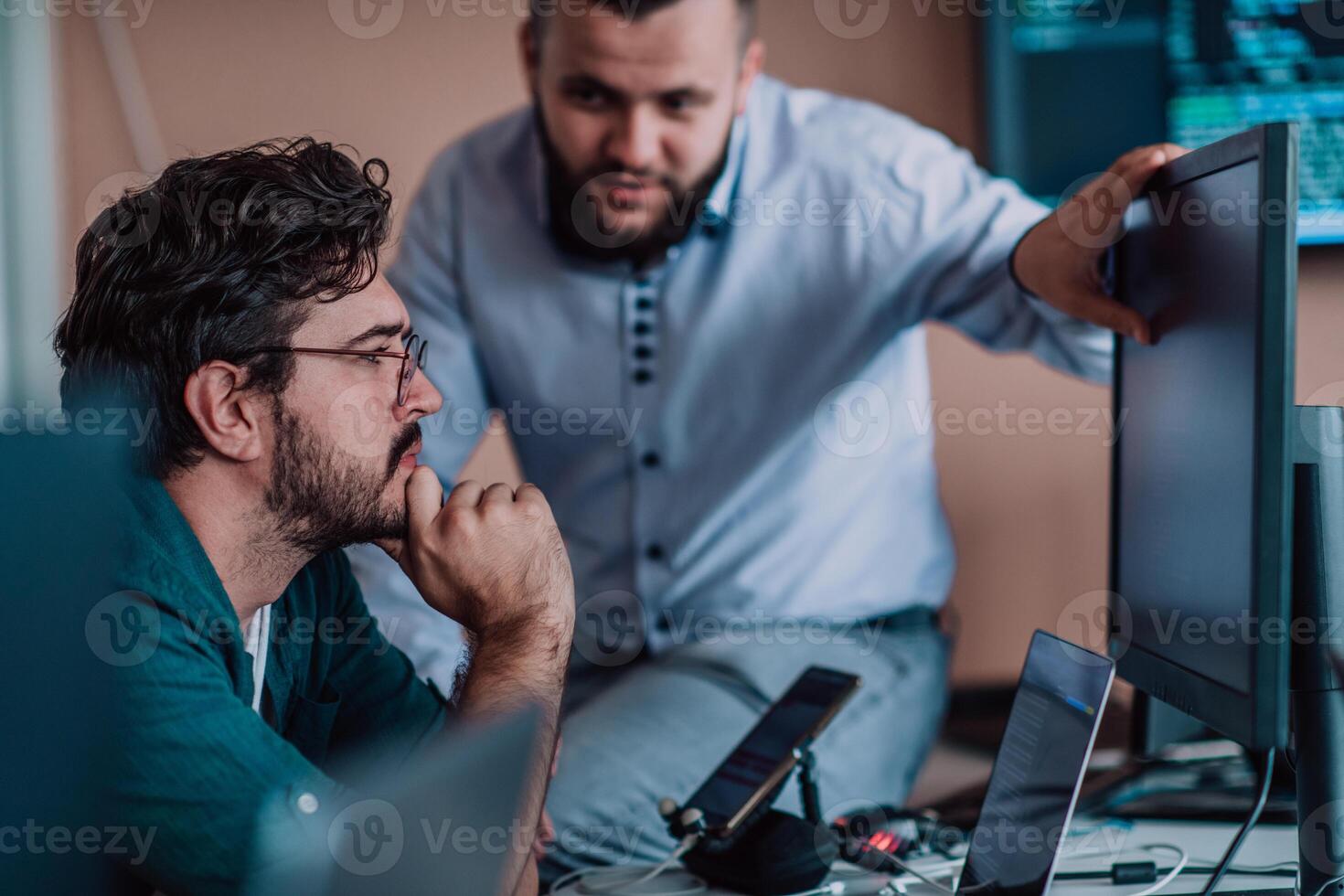 Programmers engrossed in deep collaboration, diligently working together to solve complex problems and develop innovative mobile applications with seamless functionality. photo