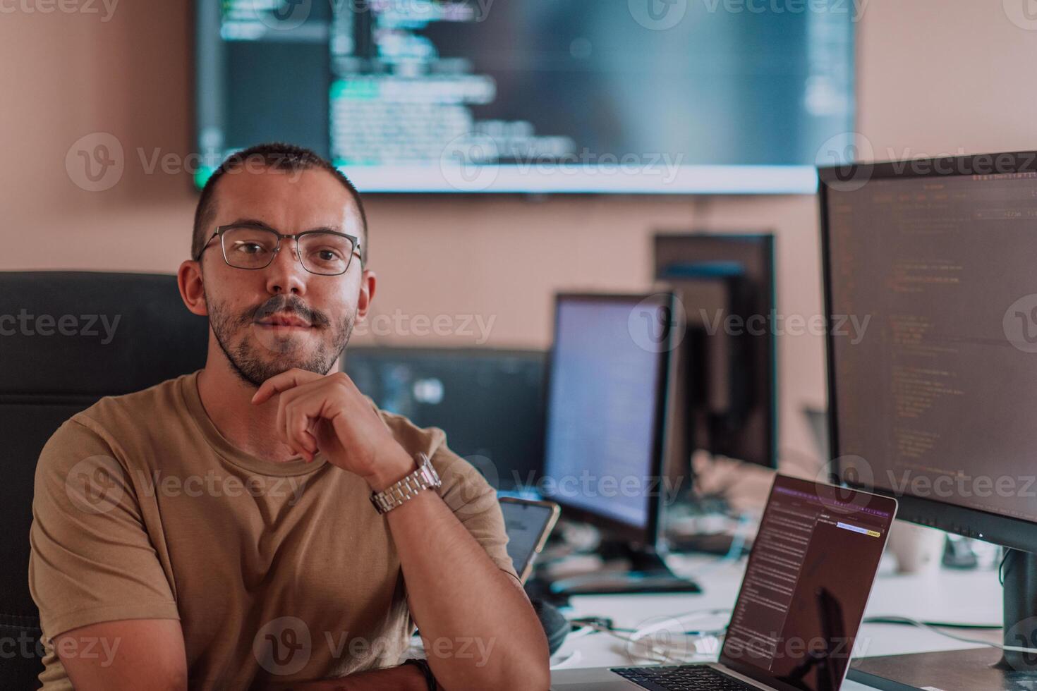 A programmer diligently testing smartphone applications while sitting in their office. photo