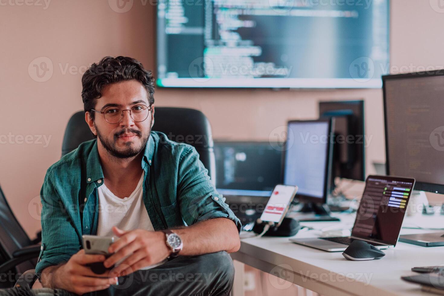 A programmer diligently testing smartphone applications while sitting in their office. photo
