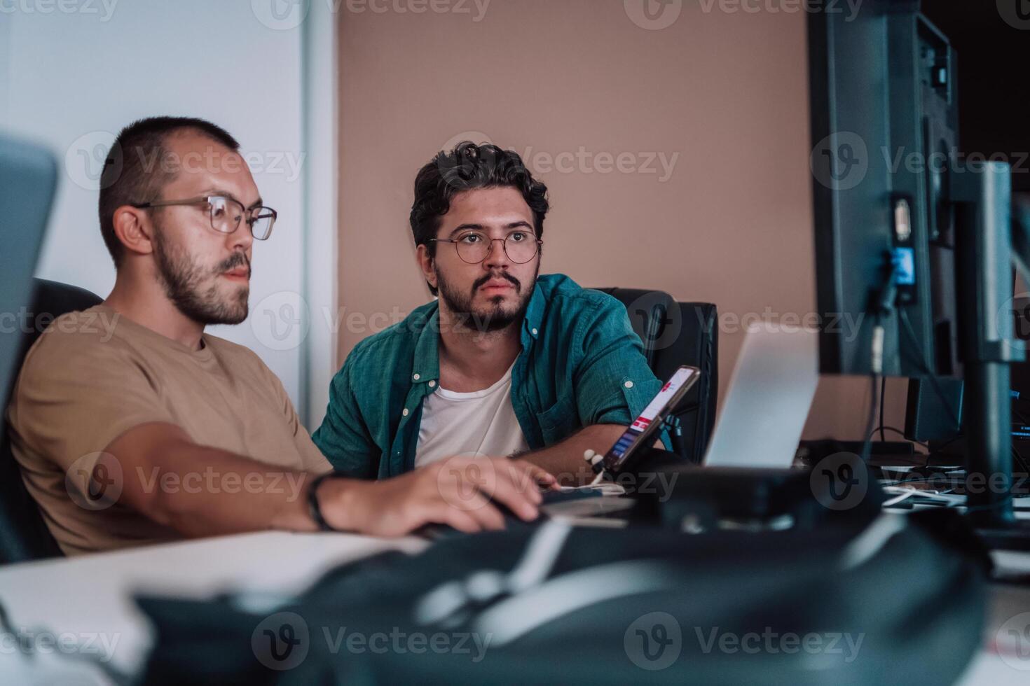 Programmers engrossed in deep collaboration, diligently working together to solve complex problems and develop innovative mobile applications with seamless functionality. photo