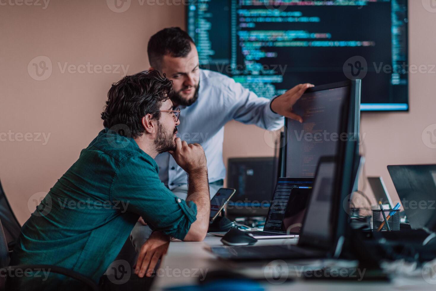 Programmers engrossed in deep collaboration, diligently working together to solve complex problems and develop innovative mobile applications with seamless functionality. photo