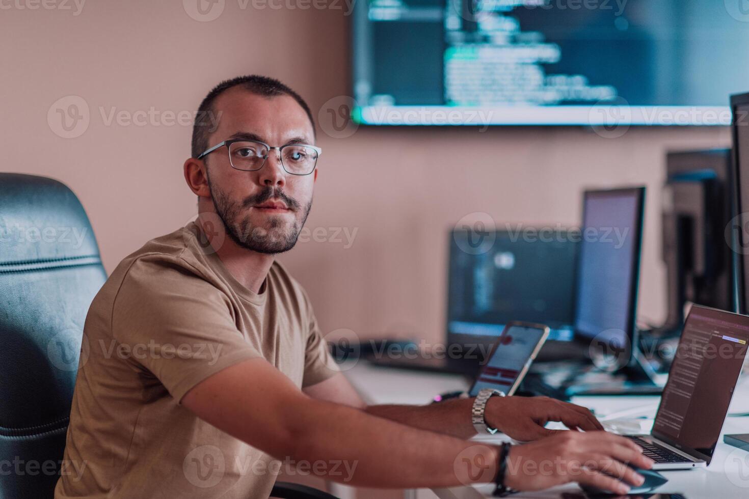 A programmer diligently testing smartphone applications while sitting in their office. photo