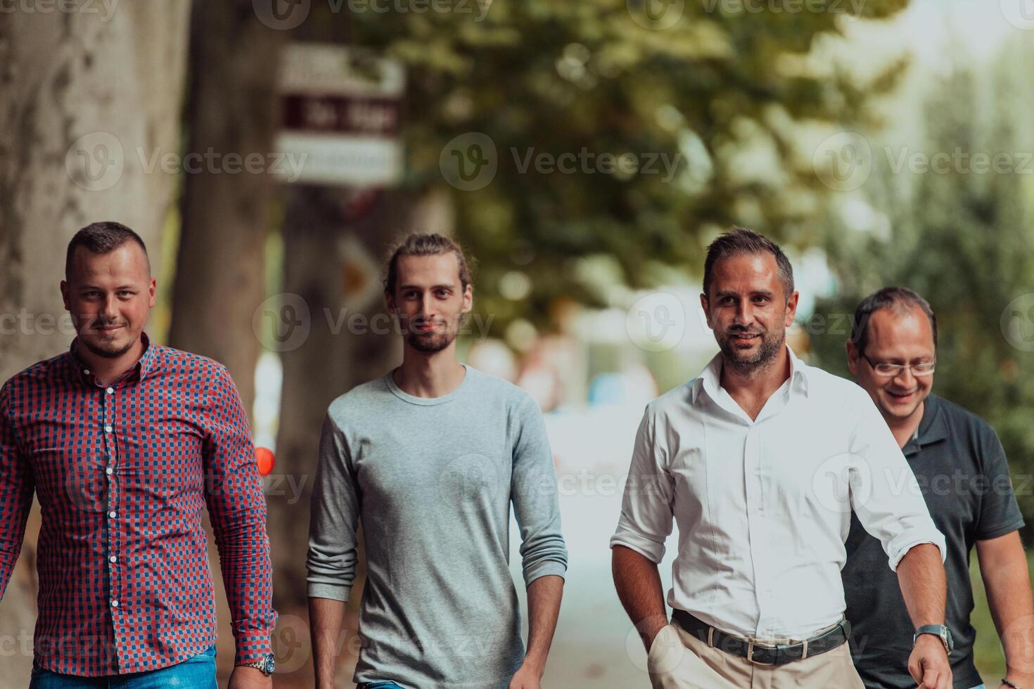 After a productive day at work, a group of diverse colleagues enjoy a leisurely stroll through a modern and natural urban setting photo