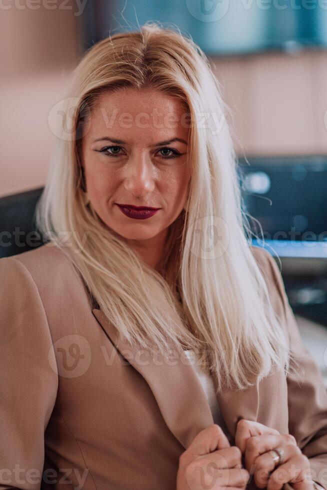 A businesswoman sitting in a programmer's office surrounded by computers, showing her expertise and dedication to technology. photo