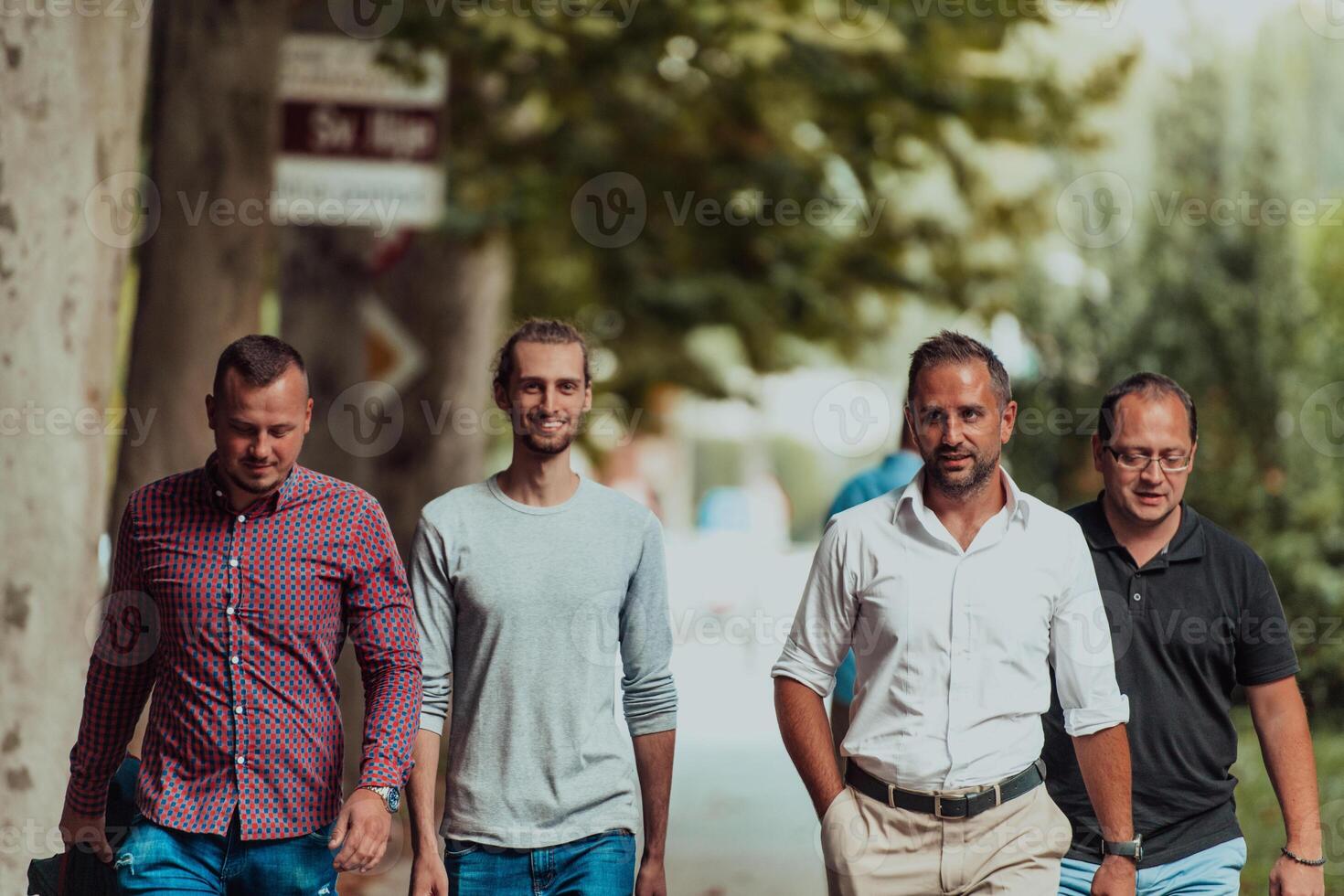 After a productive day at work, a group of diverse colleagues enjoy a leisurely stroll through a modern and natural urban setting photo