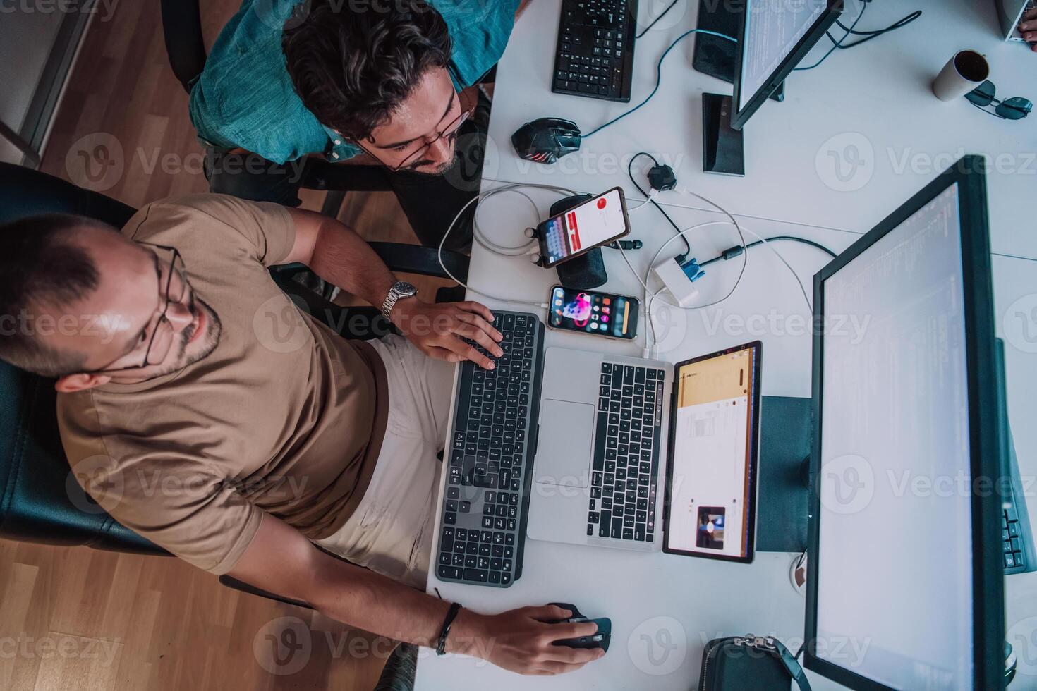 Programmers engrossed in deep collaboration, diligently working together to solve complex problems and develop innovative mobile applications with seamless functionality. photo