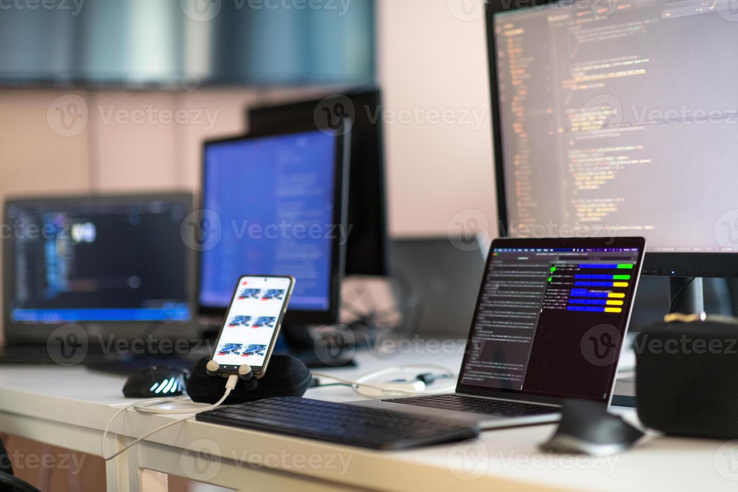 Computer screens running programming code in empty software developing agency office and computers parsing data algorithms in background. Neural network servers cloud computing in data room. photo